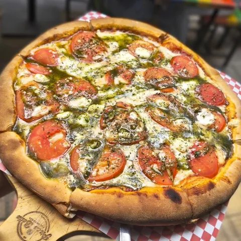 Pizza Caprese con tomate, queso de cabra y pesto