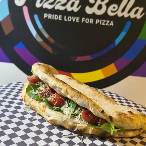 Sándwich en pan de pizza frente al logo de Pizzabella